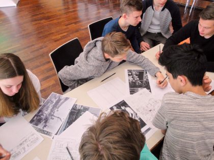 Schülerinnen und Schüler arbeiten am Tisch.