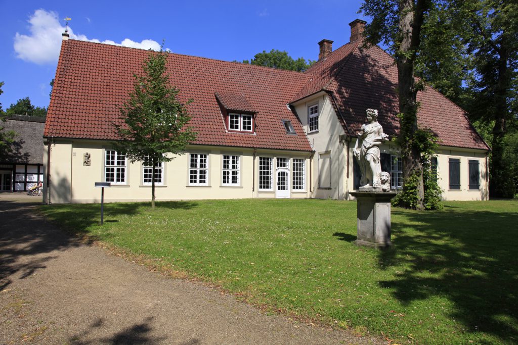 Haus Riensberg, im Vordergrund eine Statue.