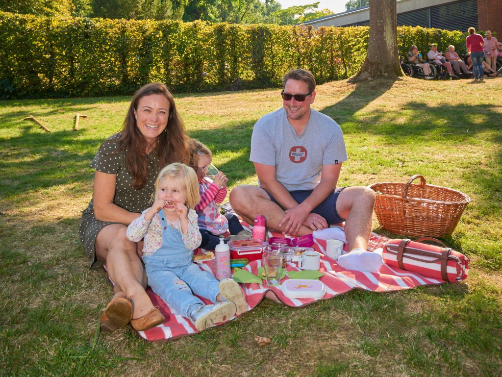 Eltern picknicken mit ihren beiden Kindern im Park