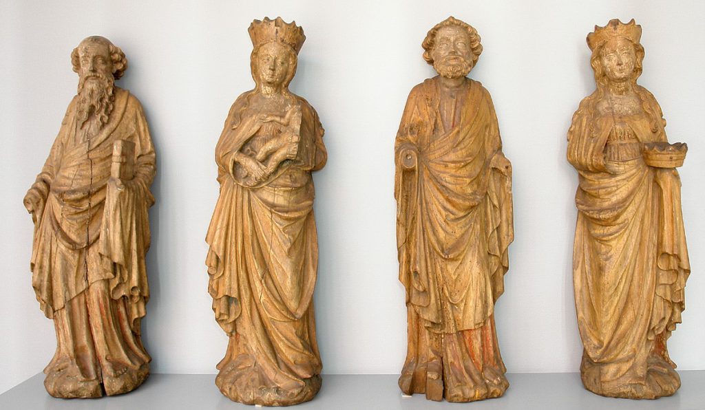 Vier Heiligenfiguren stehen nebeneinander in der Ausstellung des Focke-Museums.