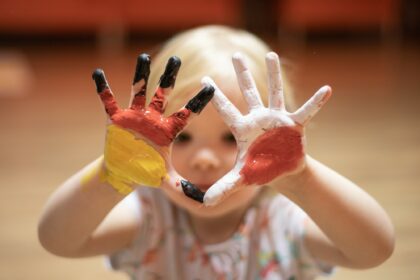 Kind mit bemalten Hände in den Farben der deutschen und polnischen Fahnen
