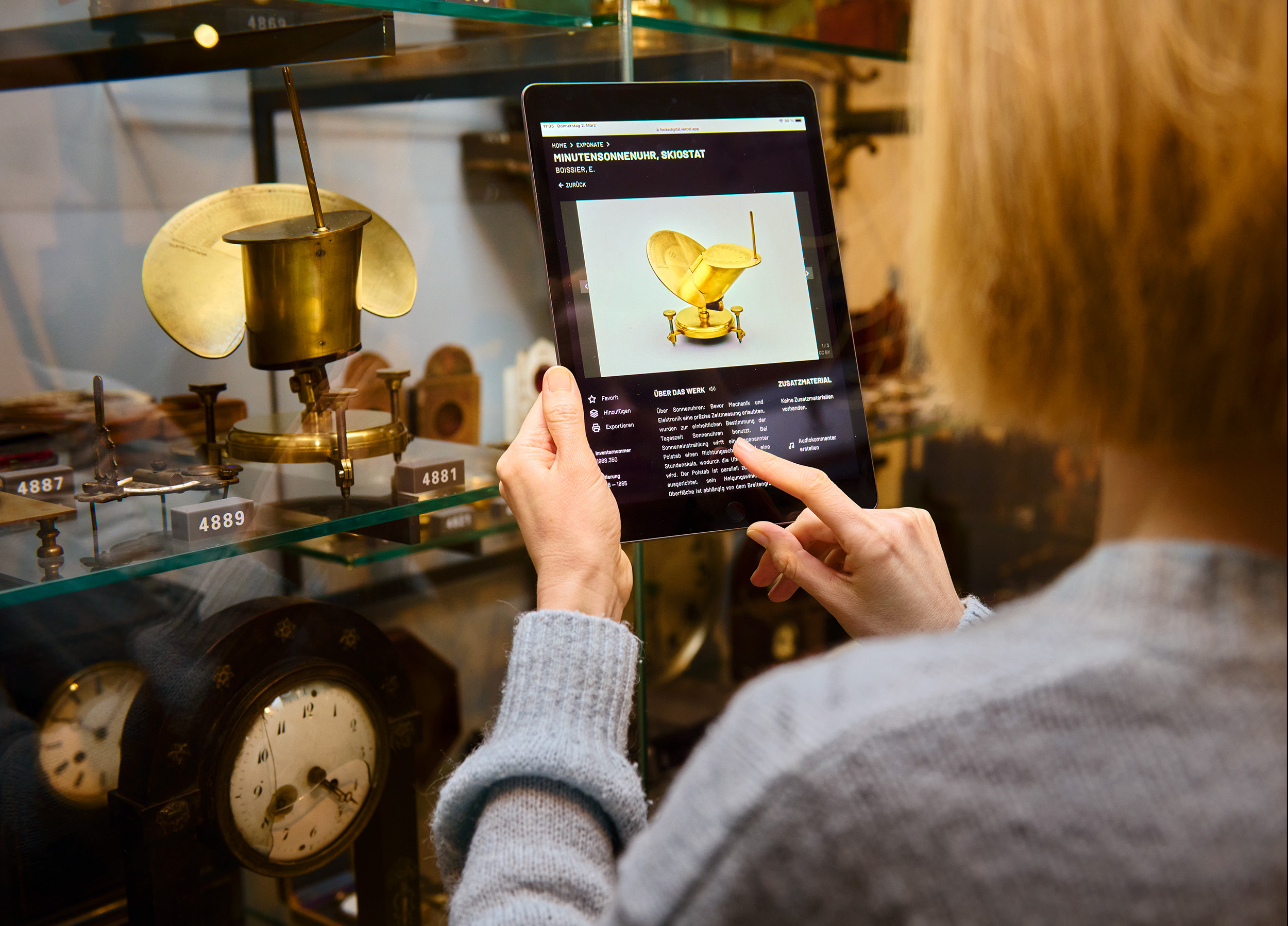 Besucherin schaut sich auf dem IPad die Online-Sammlung an.