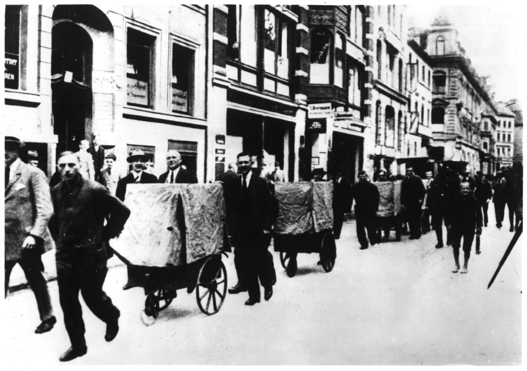 1923 werden durch eine Straße in Halle an der Saale mehrere Geldtransporter gezogen. Sie sind mit Tüchern verdeckt.
(C) Deutsches Historisches Museum