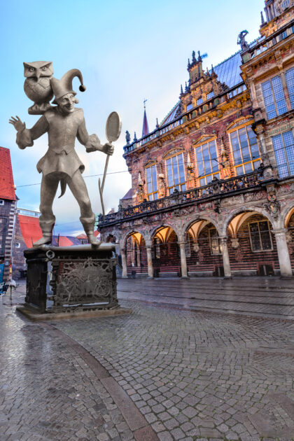 Fotomontage: Eine Statue des Till Eulenspiegels steht auf dem Marktplatz.