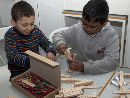 Zwei Jungs konstruieren etwas mit Technikspielzeug