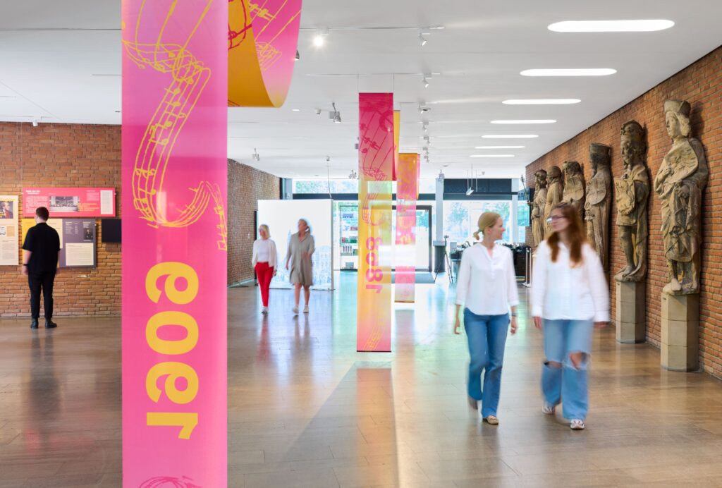 Besucherinnen und Besucher laufen durch die Ausstellung
