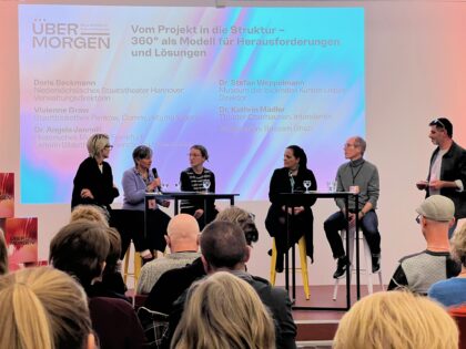 Menschen auf einem Podium bei einer Diskussion