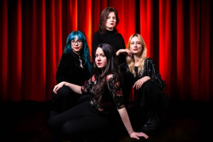 Vier Frauen vor einem roten Vorhang